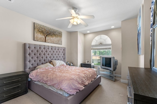 carpeted bedroom with ceiling fan and a textured ceiling