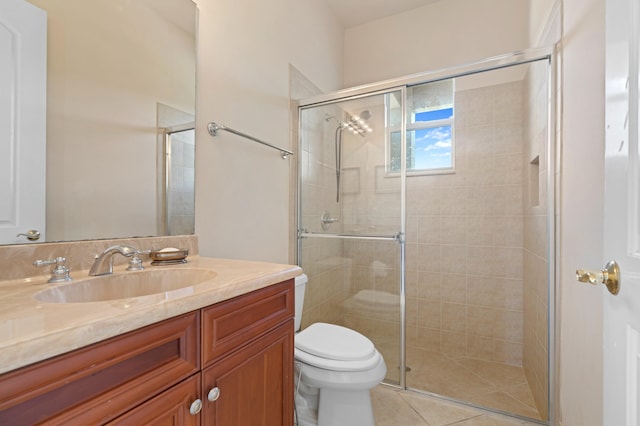 bathroom with vanity, toilet, a shower with door, and tile patterned floors