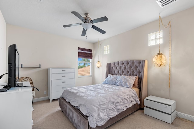 carpeted bedroom with multiple windows and ceiling fan