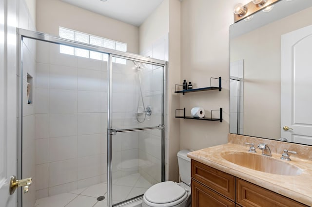 bathroom featuring vanity, a shower with shower door, and toilet