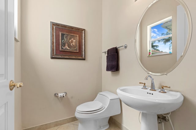 bathroom featuring toilet, sink, and tile patterned floors