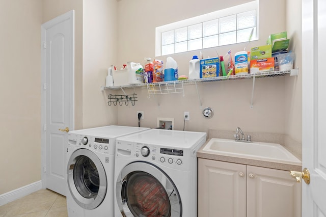 washroom featuring cabinets, light tile patterned floors, washer and dryer, and sink