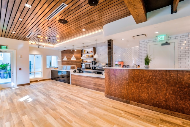 kitchen with wood ceiling, light wood-type flooring, tasteful backsplash, a notable chandelier, and decorative light fixtures