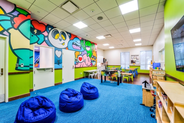 playroom featuring a drop ceiling and carpet floors