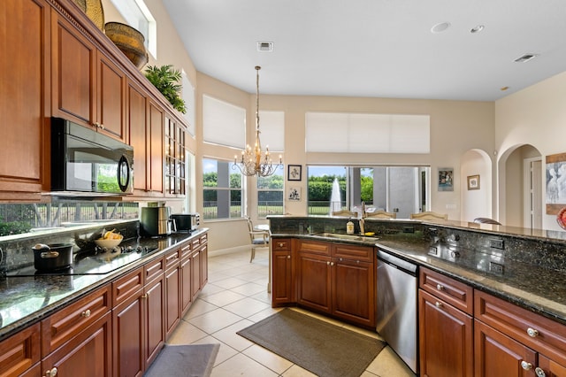 kitchen featuring dark stone counters, sink, an inviting chandelier, light tile patterned floors, and stainless steel dishwasher