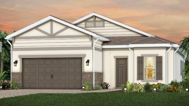 view of front of house featuring stone siding, decorative driveway, and an attached garage