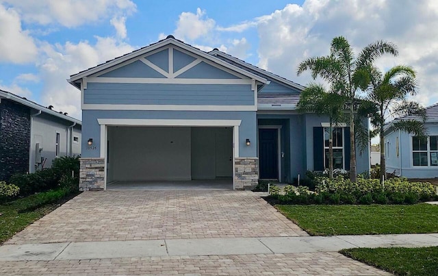 view of front of house with stone siding, decorative driveway, and stucco siding