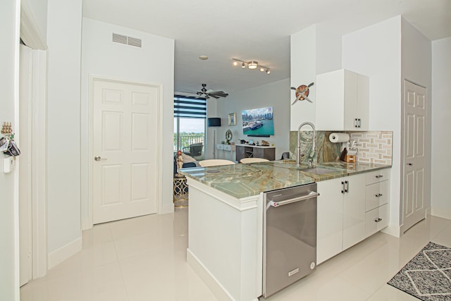 kitchen with kitchen peninsula, backsplash, sink, dishwasher, and white cabinets