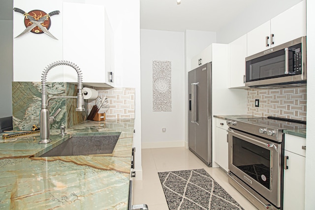 kitchen with white cabinets, decorative backsplash, and high quality appliances