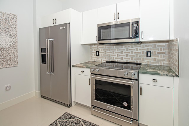 kitchen with tasteful backsplash, high quality appliances, white cabinets, and light tile patterned flooring