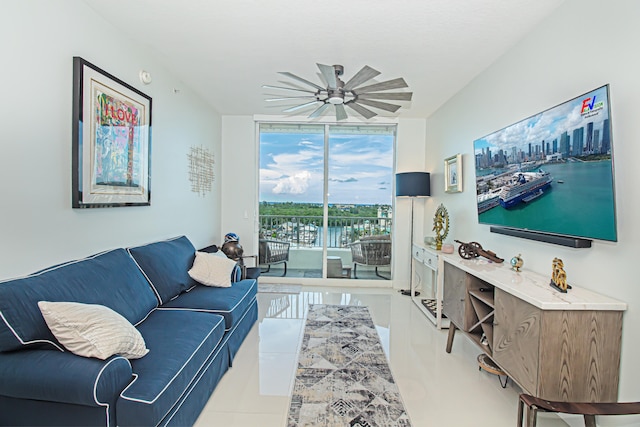 tiled living room with ceiling fan and a wall of windows