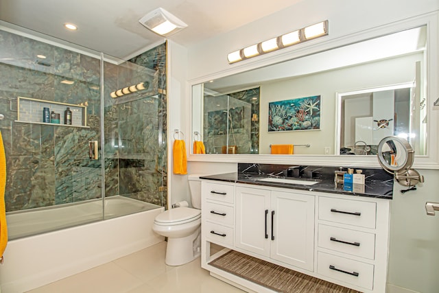 full bathroom featuring tile patterned floors, vanity, bath / shower combo with glass door, and toilet