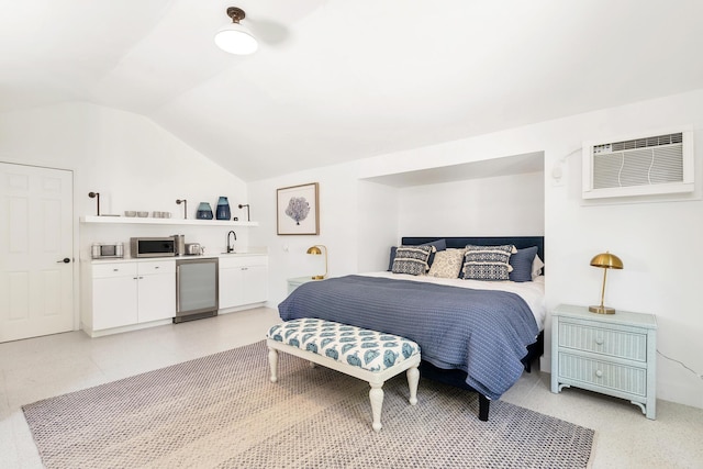 bedroom featuring a wall mounted AC, fridge, sink, and lofted ceiling