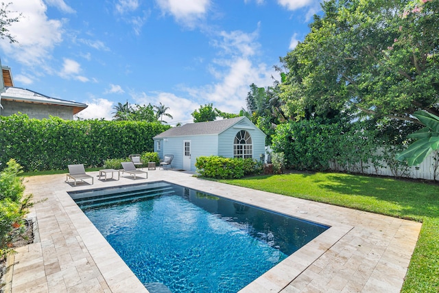 view of pool featuring a yard, an outbuilding, and a patio