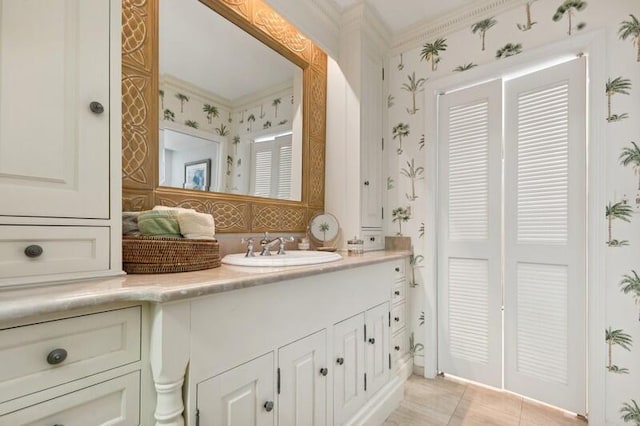 bathroom featuring tile patterned floors, crown molding, and vanity