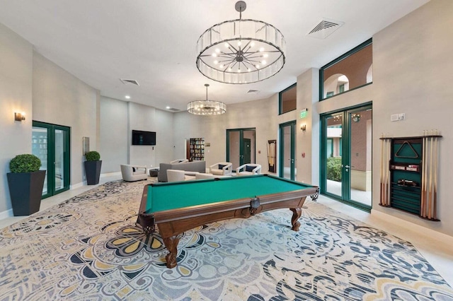 rec room featuring pool table, an inviting chandelier, french doors, and a high ceiling