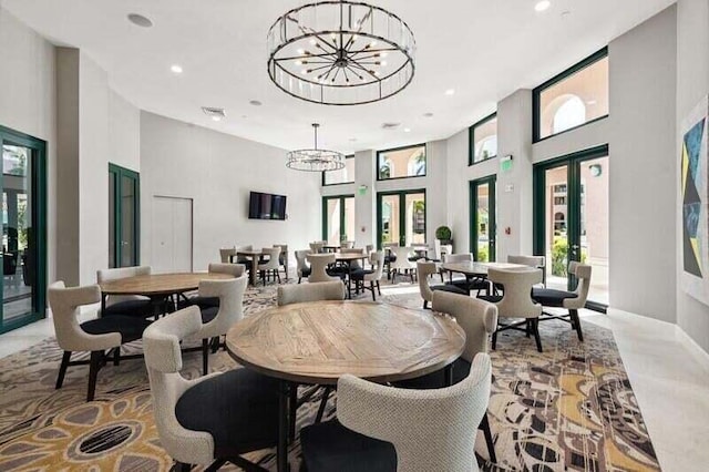 dining room with an inviting chandelier, french doors, and a high ceiling