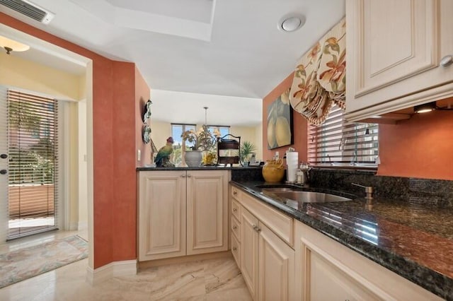 kitchen featuring cream cabinetry, dark stone countertops, and light tile patterned floors