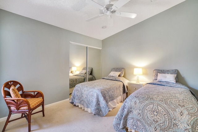 bedroom featuring lofted ceiling, ceiling fan, a textured ceiling, light carpet, and a closet