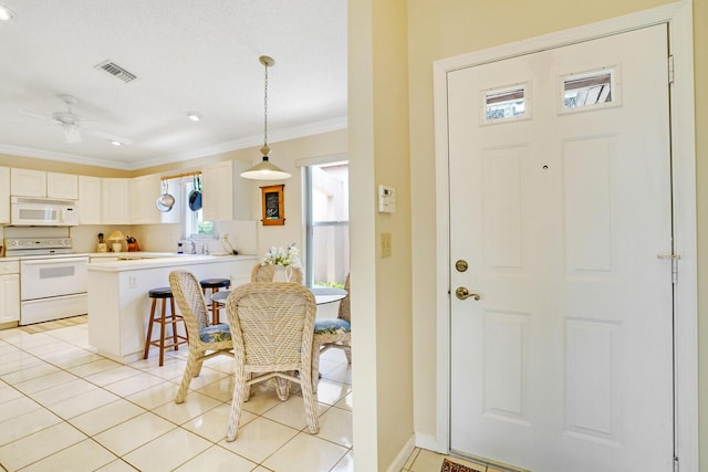 entryway with ornamental molding, ceiling fan, and light tile patterned flooring