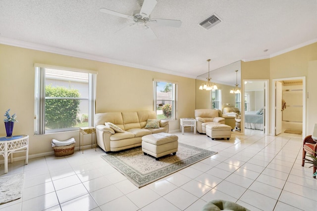 living room featuring light tile patterned floors, crown molding, ceiling fan with notable chandelier, and a textured ceiling