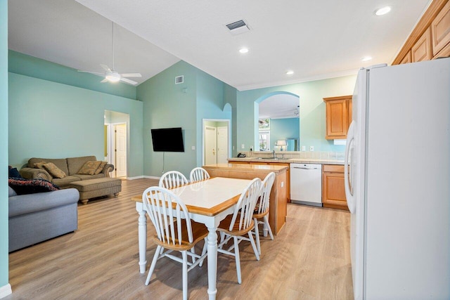 dining space featuring ceiling fan, lofted ceiling, light hardwood / wood-style floors, and sink