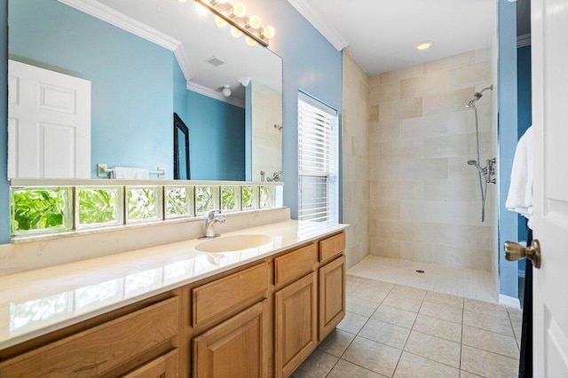 bathroom featuring a tile shower, tile patterned floors, vanity, and crown molding