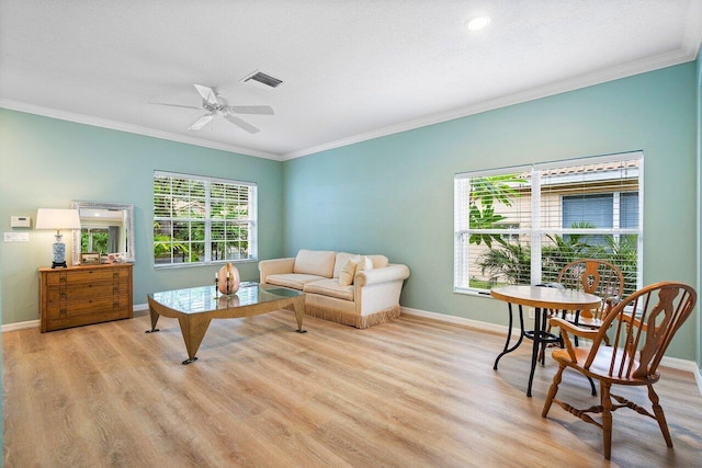 living room featuring light hardwood / wood-style floors, a textured ceiling, crown molding, and ceiling fan