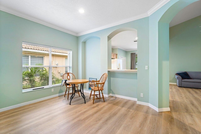 living area with a textured ceiling, crown molding, and light hardwood / wood-style flooring