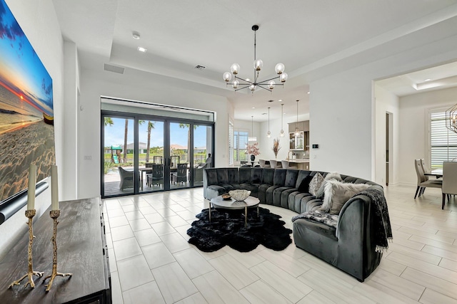 living room with a raised ceiling and a chandelier