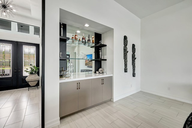 bar with french doors and gray cabinetry