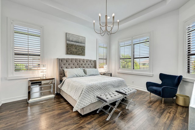 bedroom with a raised ceiling, a chandelier, and dark wood-type flooring