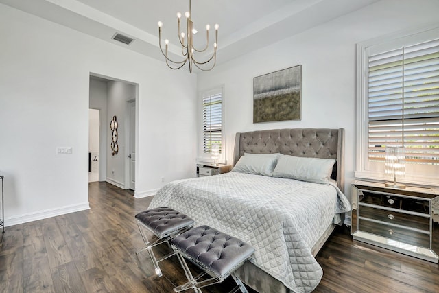 bedroom with dark hardwood / wood-style flooring and a chandelier