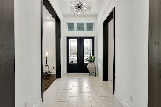 entryway featuring french doors and a chandelier