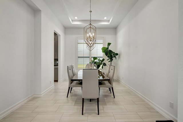 tiled dining area with a notable chandelier and a tray ceiling