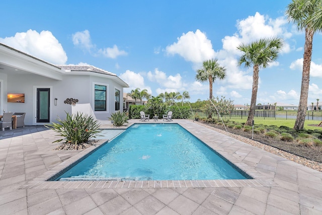 view of swimming pool with pool water feature and a patio area