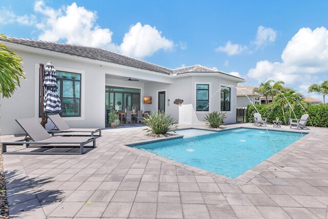 view of swimming pool featuring pool water feature, ceiling fan, and a patio area