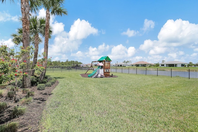 view of playground featuring a lawn and a water view