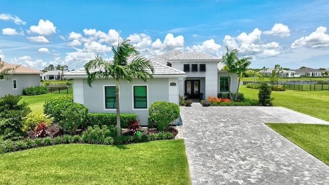 mediterranean / spanish house with french doors and a front lawn