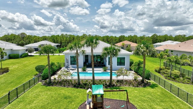 exterior space featuring a playground, a patio area, a fenced in pool, and a yard