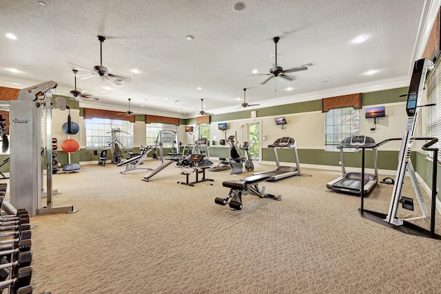 exercise room featuring carpet, ceiling fan, ornamental molding, and a textured ceiling