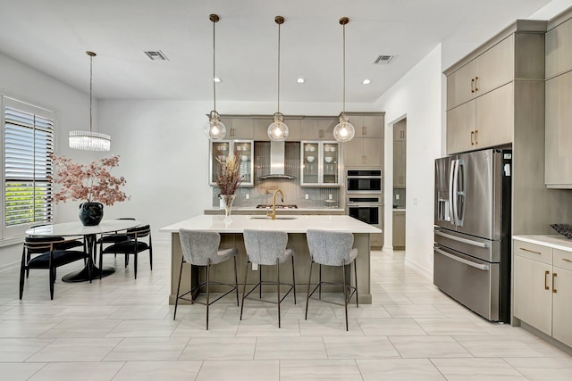 kitchen featuring pendant lighting, decorative backsplash, wall chimney range hood, and stainless steel appliances