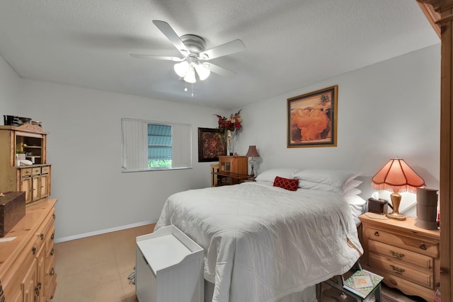 bedroom featuring light tile patterned floors, a textured ceiling, and ceiling fan