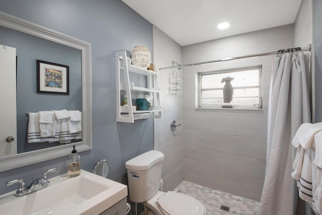 bathroom with a shower with shower curtain, vanity, and toilet