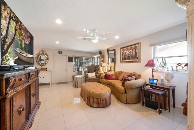 living room featuring ceiling fan, a healthy amount of sunlight, light tile patterned floors, and a textured ceiling