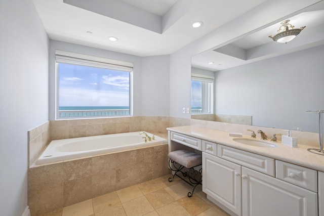 bathroom featuring tile patterned floors, tiled bath, plenty of natural light, and vanity