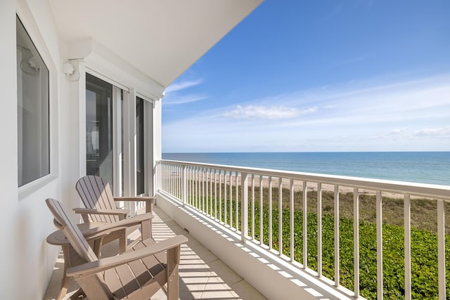 balcony with a beach view and a water view