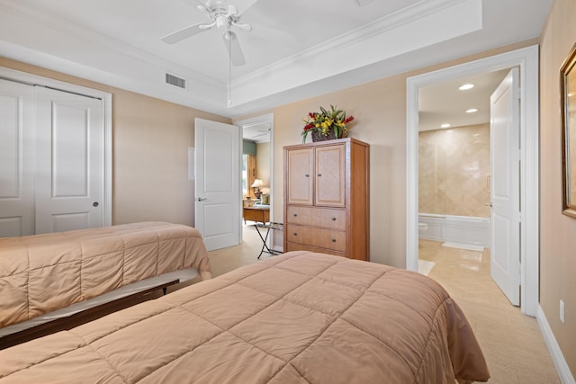 bedroom with connected bathroom, a closet, ceiling fan, and a tray ceiling