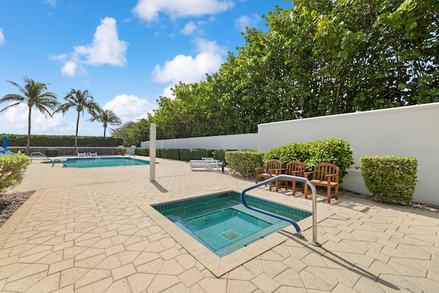 view of swimming pool featuring an in ground hot tub and a patio