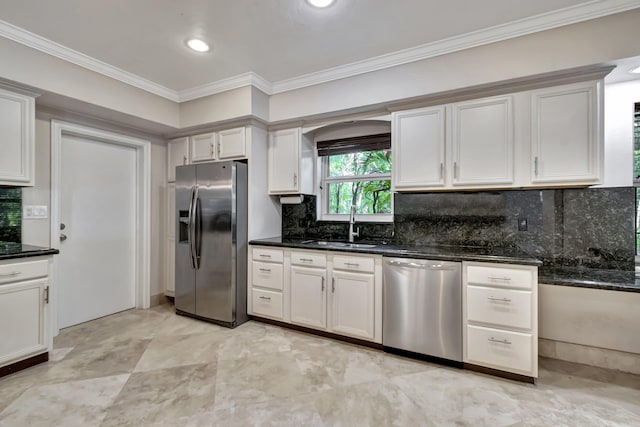 kitchen with sink, appliances with stainless steel finishes, ornamental molding, white cabinets, and dark stone counters